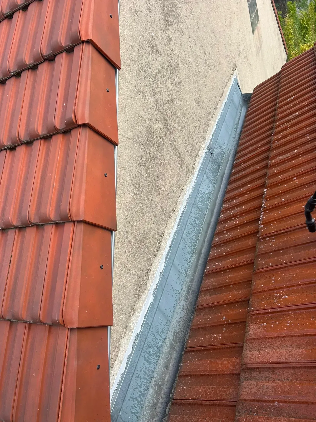 Bande de zinc le long du mur mitoyen sur tout le rampant d'une toiture en tuiles à Villejuif
