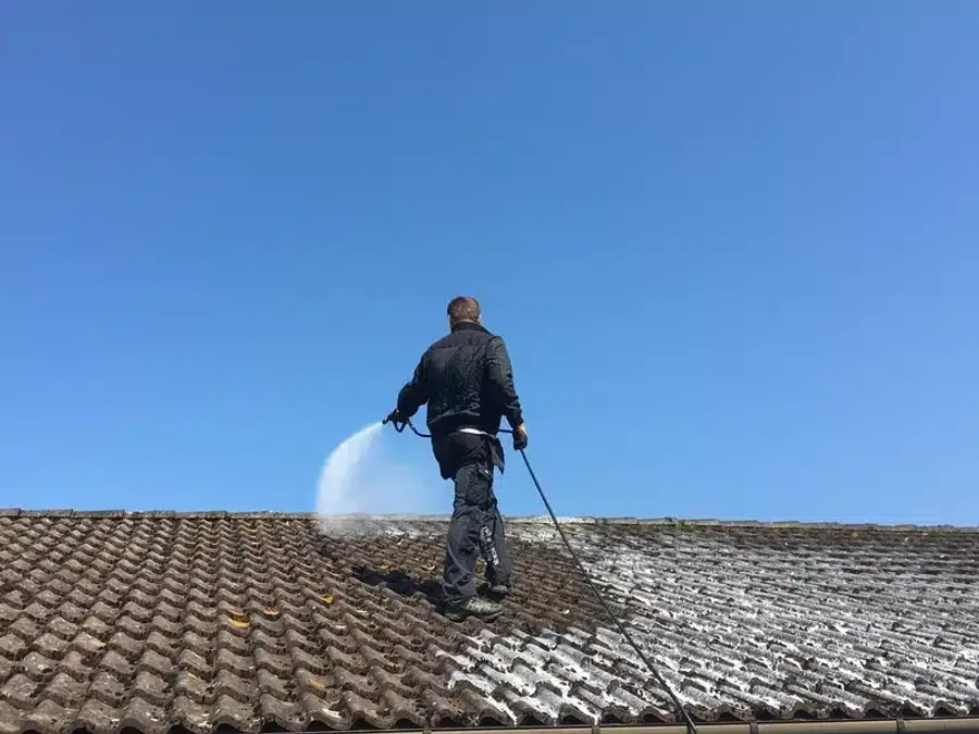 Démoussage de toiture en cours — opérateur sur toit en pleine intervention
