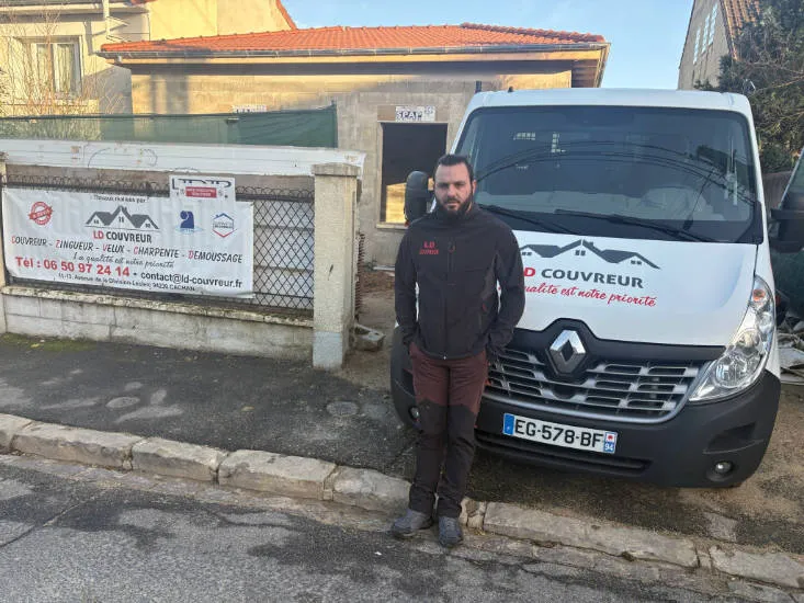 Dyllon Lafleur, artisan couvreur LD Couvreur, devant sa camionnette et le panneau de l'entreprise