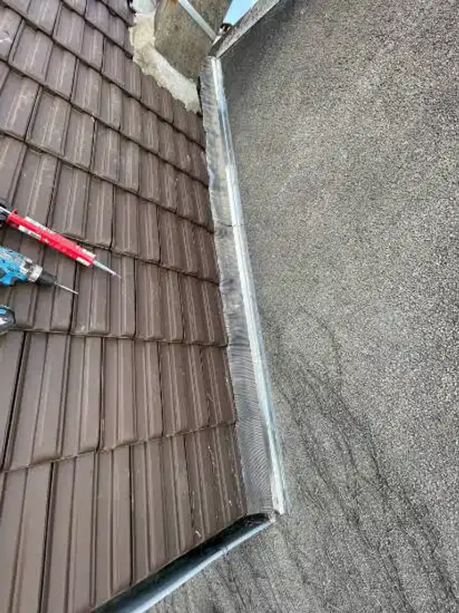 Pose d’un raccord en zinc entre toiture en tuiles et toiture plate — chantier en cours LD Couvreur
