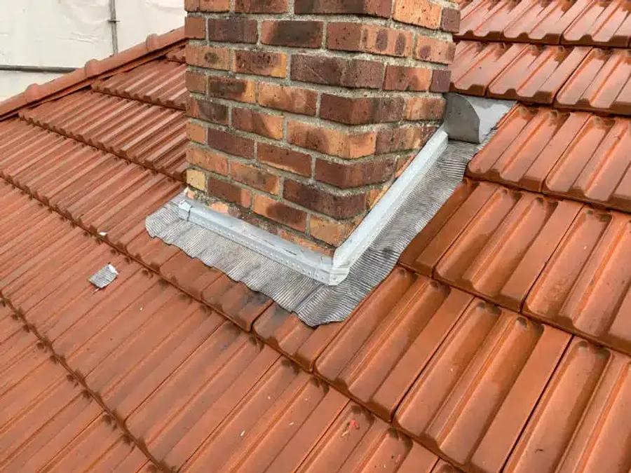 Solin de cheminée en zinc fraîchement posé sur toiture en tuiles — finition LD Couvreur 94